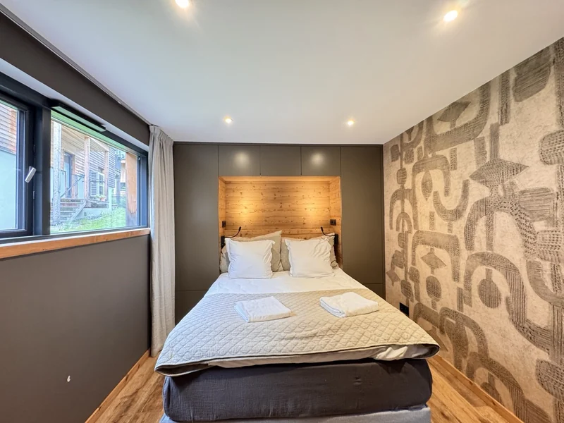 Chambre avec spots intégrés au plafond autour du lit.