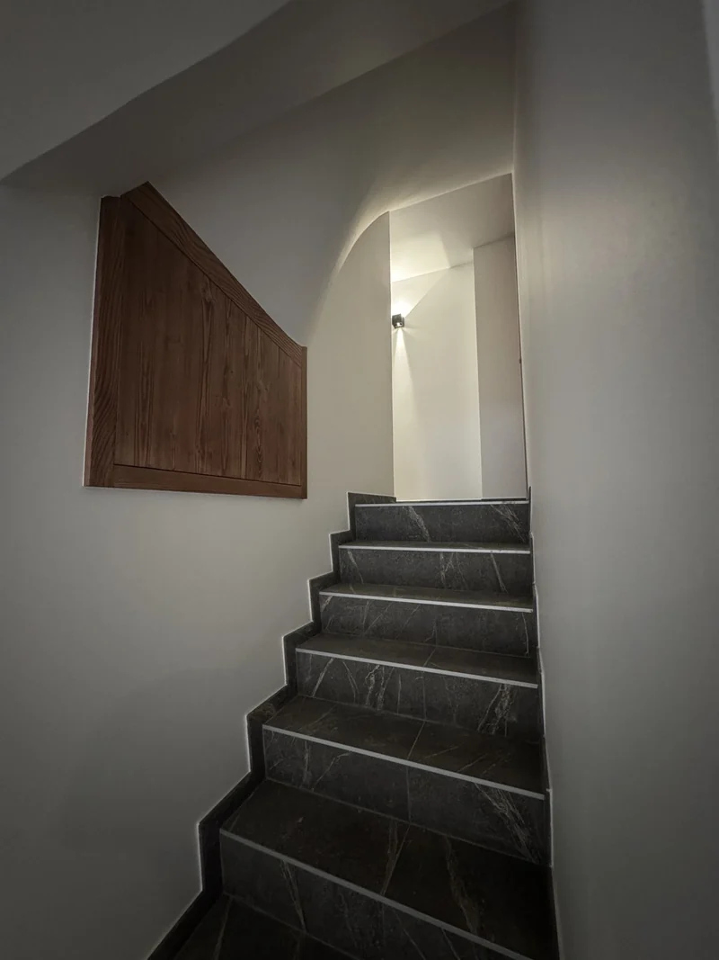 Escalier intérieur éclairé au niveau du palier et de la montée.