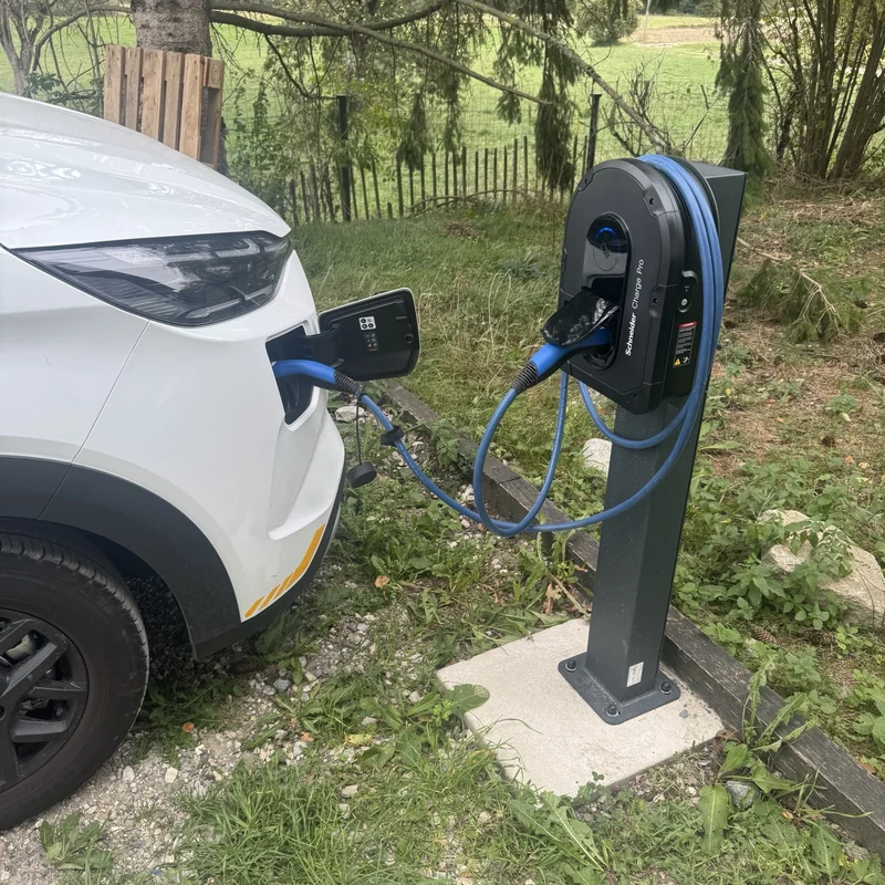 Mon véhicule branché à une borne Schneider Charge Pro sur pied, avec le câble de recharge bleu.